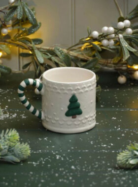 Tasse en céramique blanche texturée avec motif sapin, anse rayée