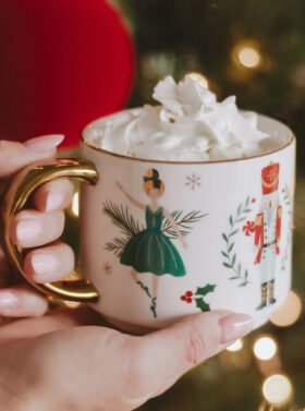 Tasse en porcelaine avec motifs de noël et sa poignée dorée.